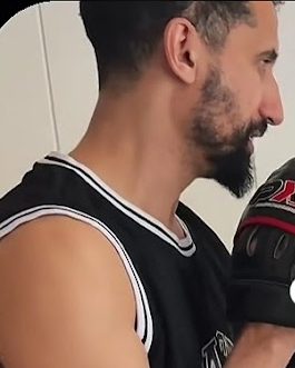 Trainer hält Pratzen für ein Kind im Training